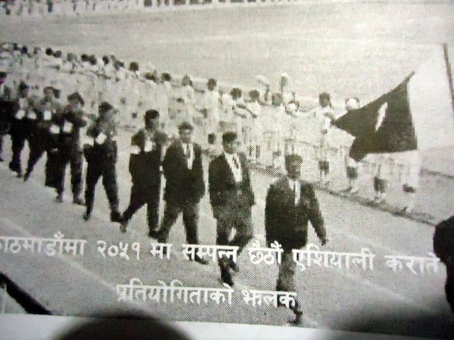 Black and white archival photograph of karateka marching with the national flag in the opening ceremony of the 6th Asian Karate Championship, Kathmandu, 2051 B.S.