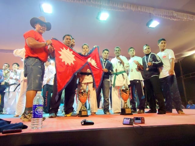 A podium ceremony with the Nepali flag at the 13th Asian Open Kyokushin Karate Tournament.
