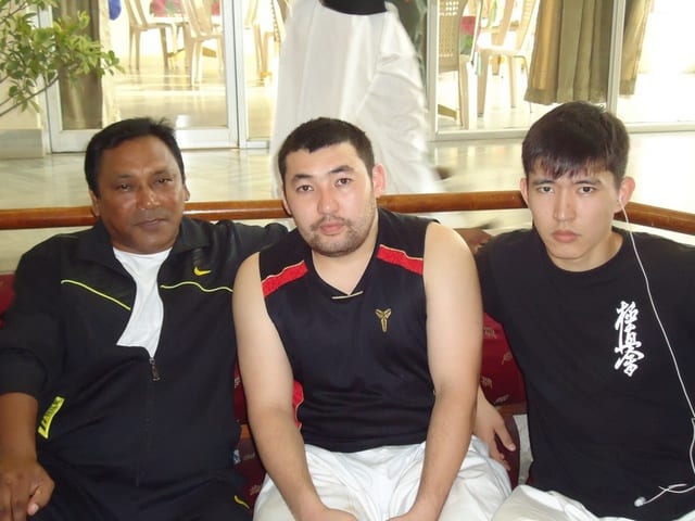 An athlete holding a large trophy, draped in the Nepali flag, at the 13th Asian Open.