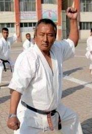 Shihan Jagat Prasad Gauchan with his fist raised in a stadium.